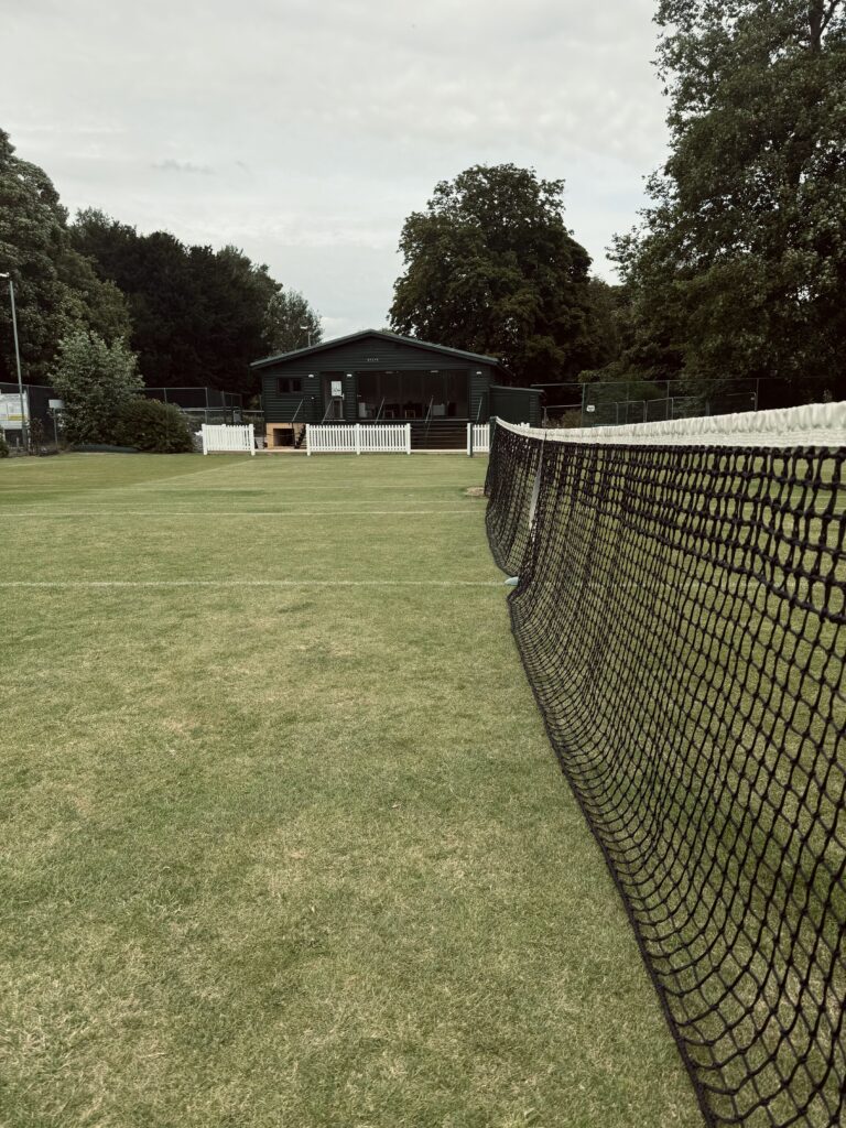 Tennis grass courts and new clubhouse in the backround.