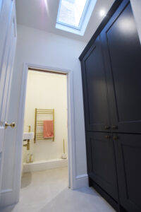 This is a photo of a utility room with a skylight and room for washing and drying machines. In the backround the open door leads to the hidden WC. A smart way to create usefull space hidden from the main kitchen area,with natural light and ventilation.