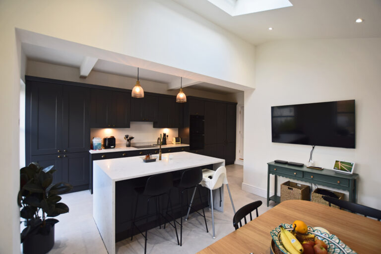 Kitchen extension , Dark kitchen, white marble island, skylights and rear side window and french door for natural light.